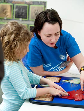 A University of Edinburgh student helps a girl with the Pangaea exhibit during a science festival