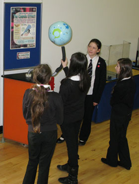 A senior pupil assists a group of girls with the Coanda Effect exhibit
