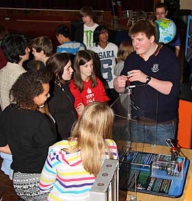 A senior pupil demonstates the Mechanical Centrifuge exhibit to a group of four girls during a school visit